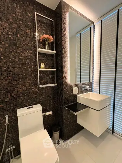 Modern bathroom with sleek design, featuring mosaic tiles and contemporary fixtures.