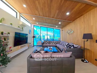 Luxurious modern living room with wooden ceiling and large glass doors opening to a stunning view.