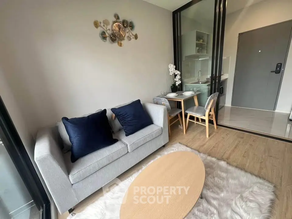 Modern living room with cozy sofa, dining area, and open kitchen in stylish apartment.