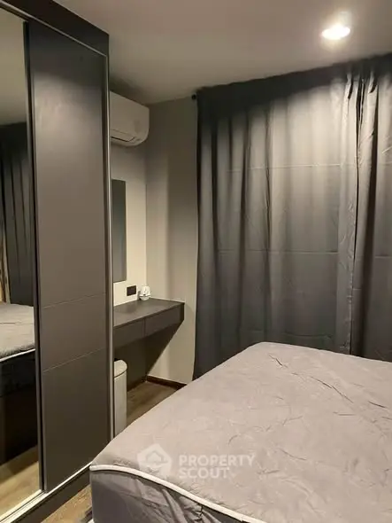 Cozy modern bedroom with mirrored wardrobe and elegant gray curtains.
