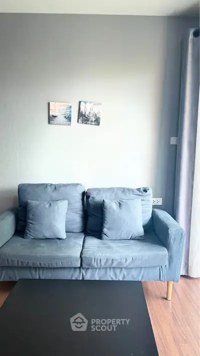 Cozy living room with blue sofa and wall art, perfect for relaxation.