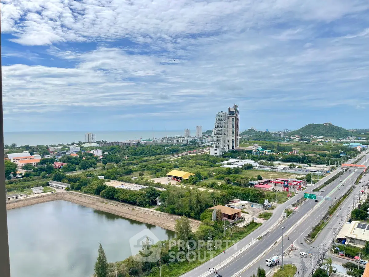 Stunning panoramic view of cityscape with lush greenery and distant ocean horizon.