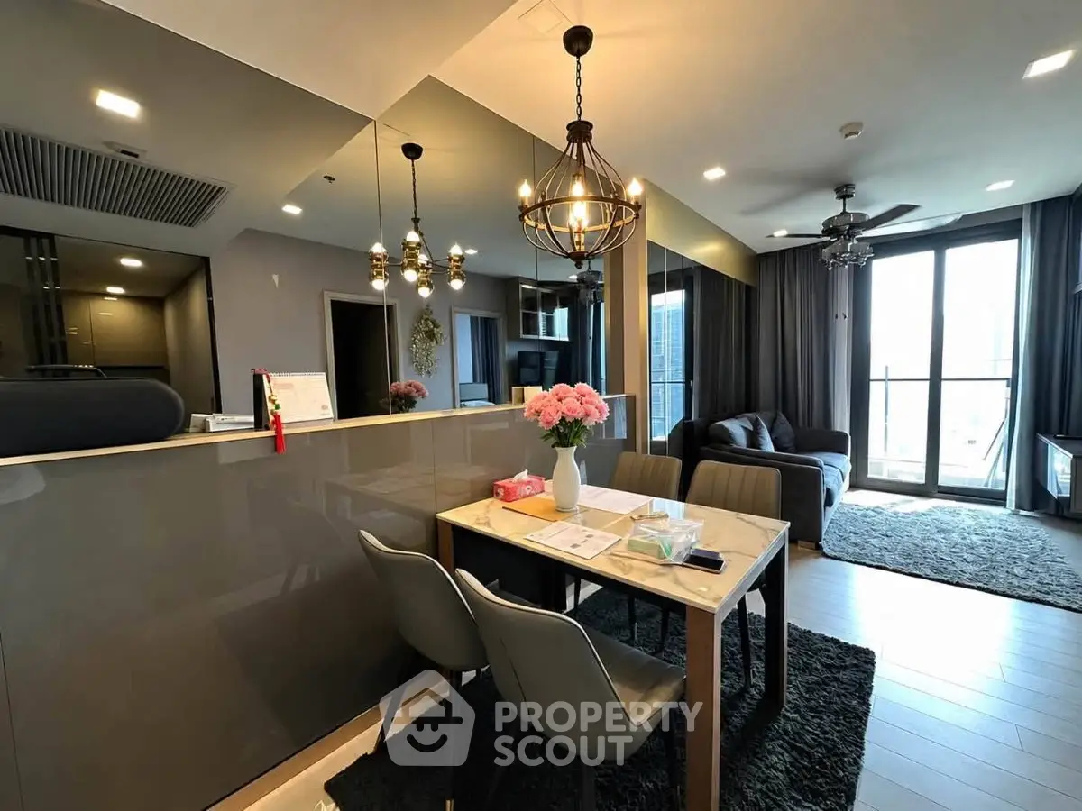 Modern living room with elegant dining area and large windows in a stylish apartment.