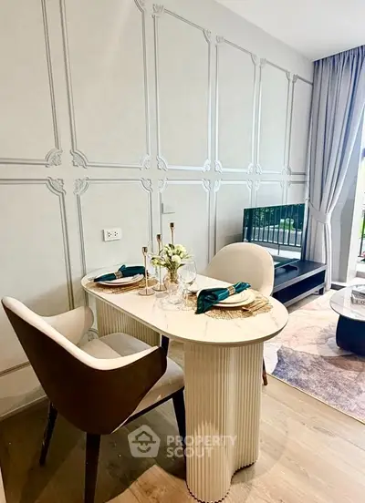Elegant dining area with stylish table and chairs in modern living room, featuring chic decor and natural light.