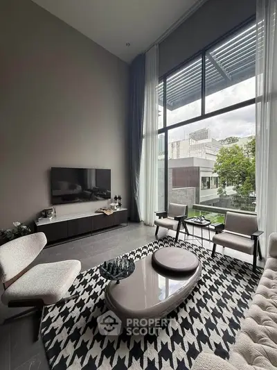 Modern living room with high ceilings and large windows offering a stunning view.