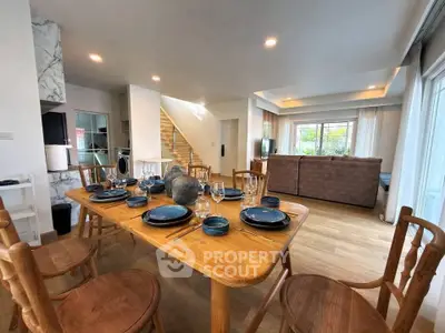 Spacious open-plan living and dining area with elegant wooden furniture and modern decor.