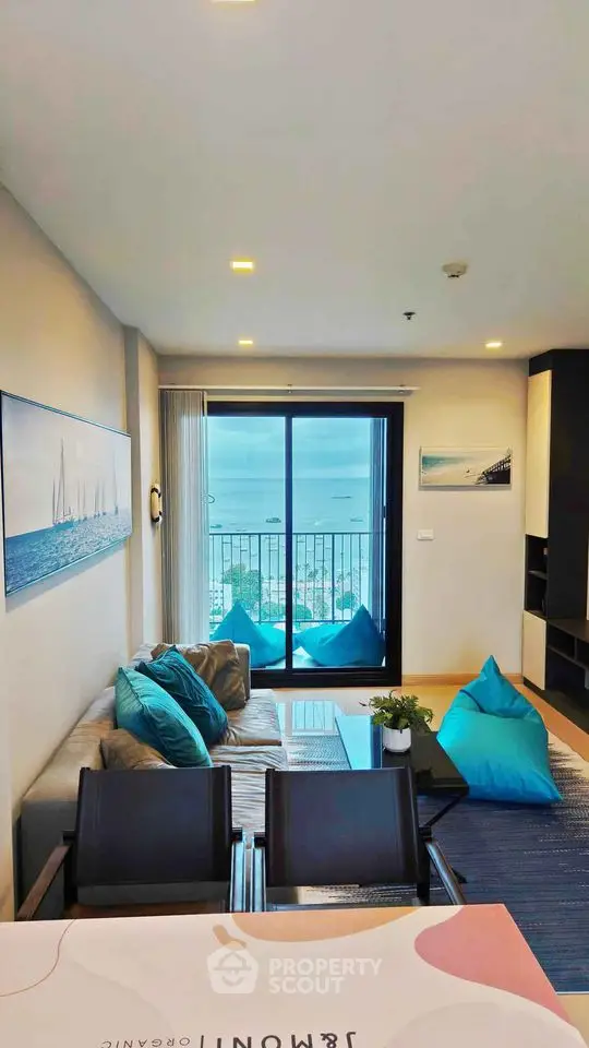 Modern living room with ocean view, stylish decor, and balcony access