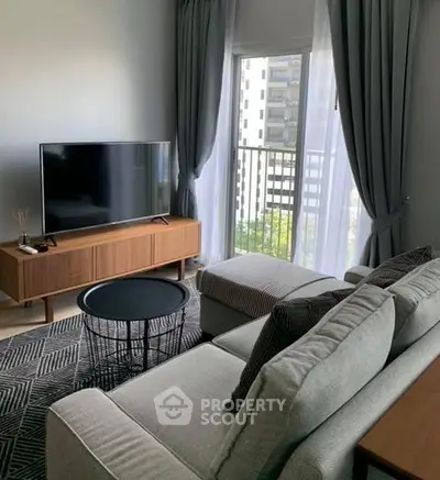 Modern living room with sleek furniture and large window view.