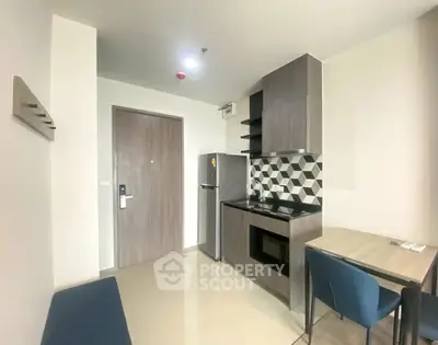 Modern compact kitchen with sleek cabinetry and stylish backsplash in a cozy apartment.