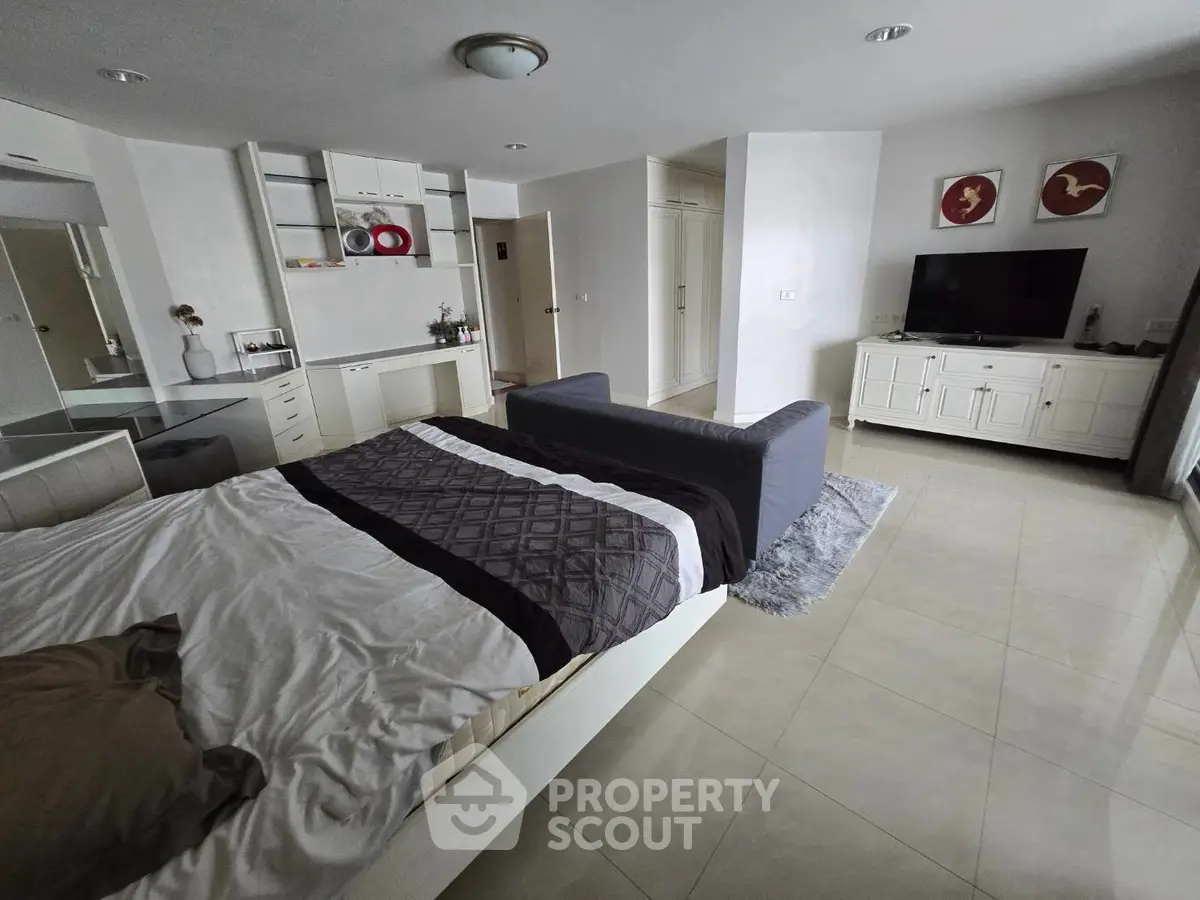 Spacious modern bedroom with stylish decor and cozy seating area