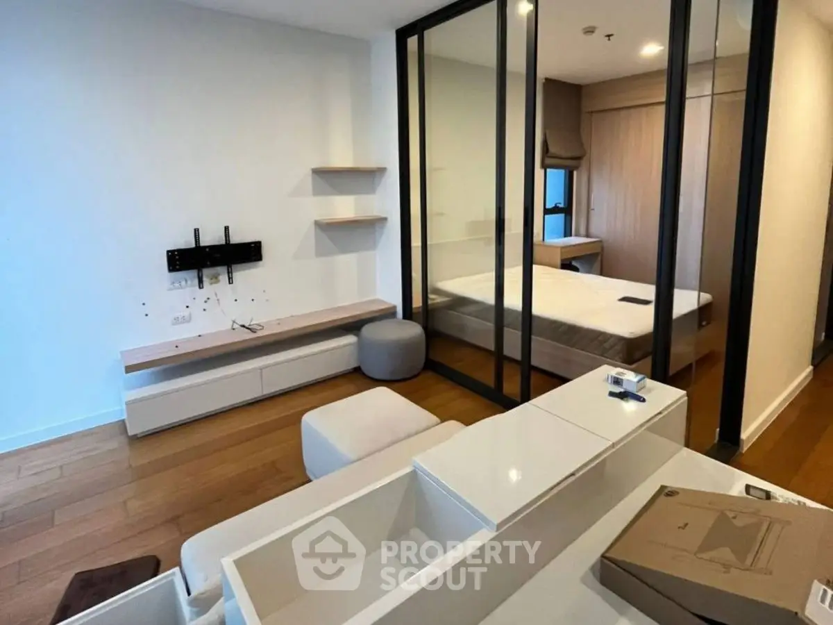 Modern bedroom with glass partition and sleek wooden flooring