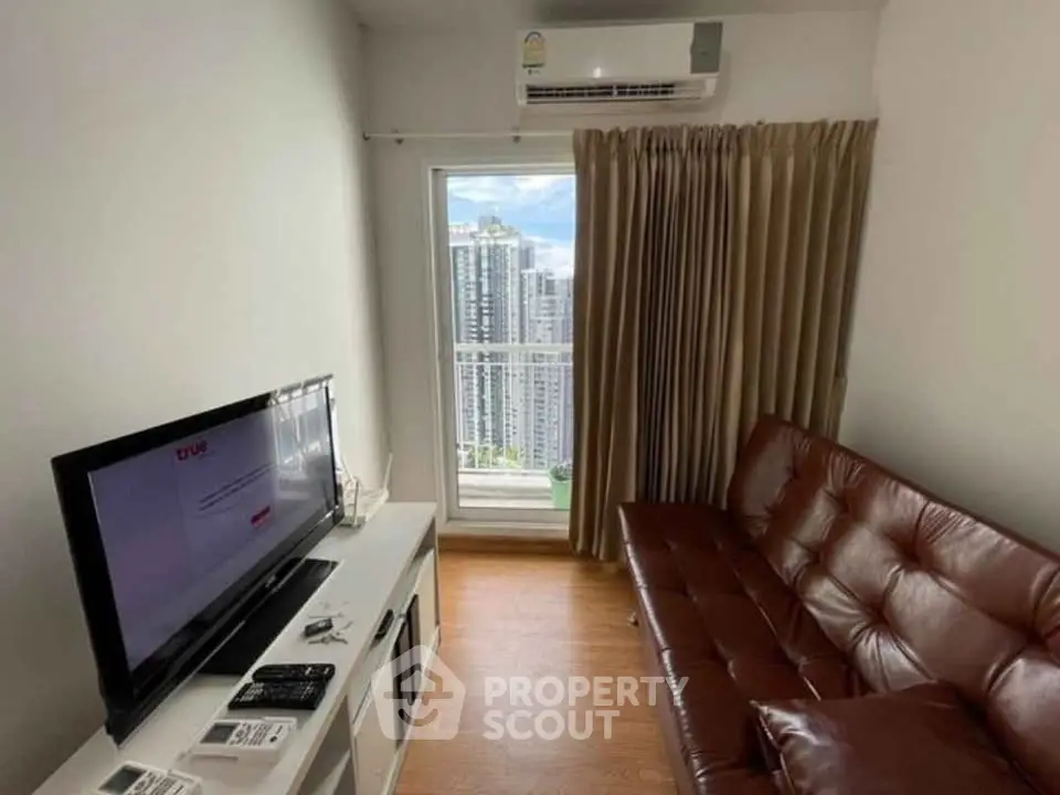 Cozy living room with leather sofa and city view from window, featuring modern TV setup.
