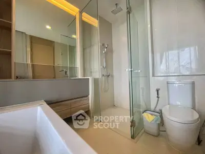 Modern bathroom with glass shower and bathtub in sleek apartment