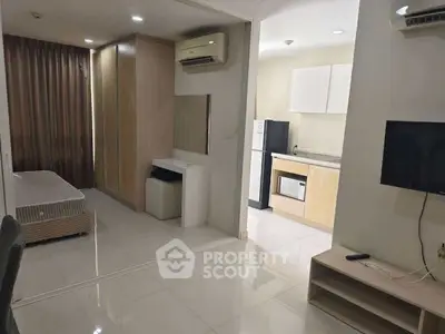 Modern studio apartment with open layout and sleek kitchen appliances.