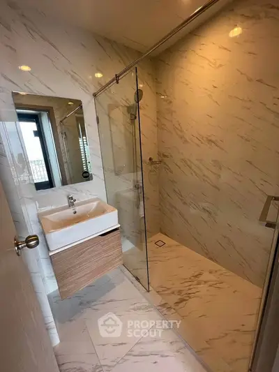 Modern bathroom with elegant marble tiles and glass shower enclosure