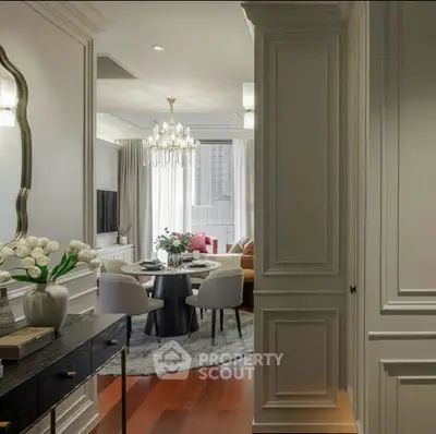 Luxurious living room with elegant decor and chandelier lighting, featuring a cozy dining area and stylish furnishings.