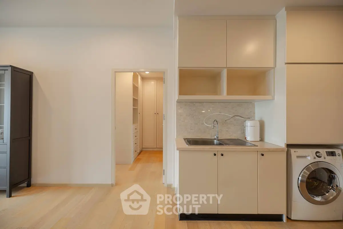 Modern kitchen with washing machine and ample storage in a stylish apartment
