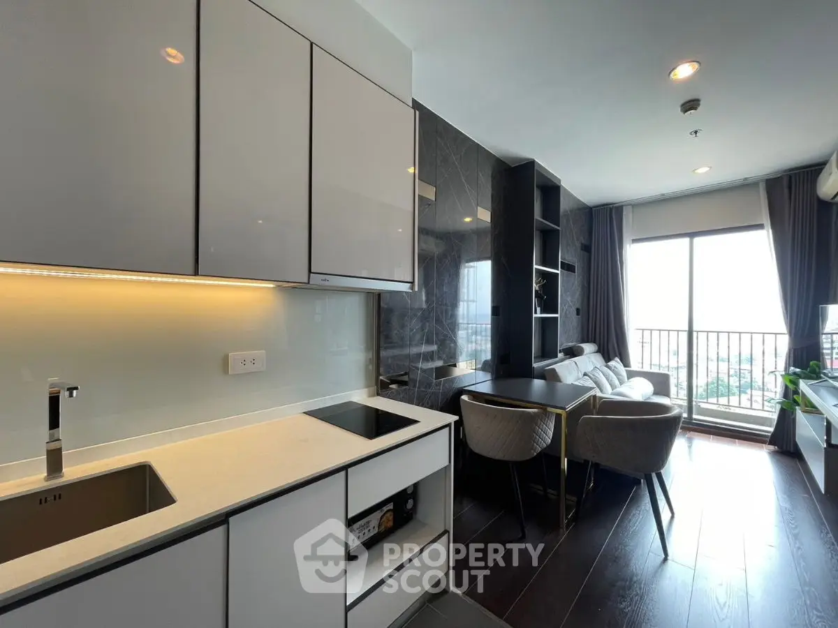 Modern open-layout kitchen and living room with sleek design and balcony view.