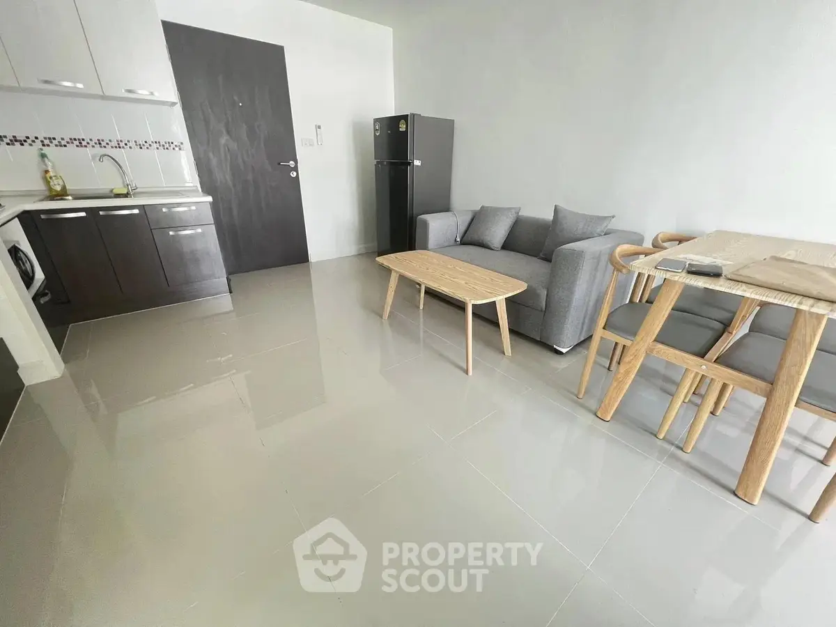 Modern open-plan living room with sleek kitchen and stylish furniture in a contemporary apartment.