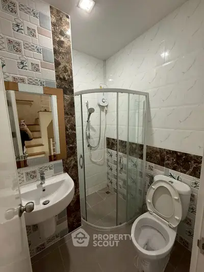 Modern bathroom with stylish tiles and corner shower enclosure