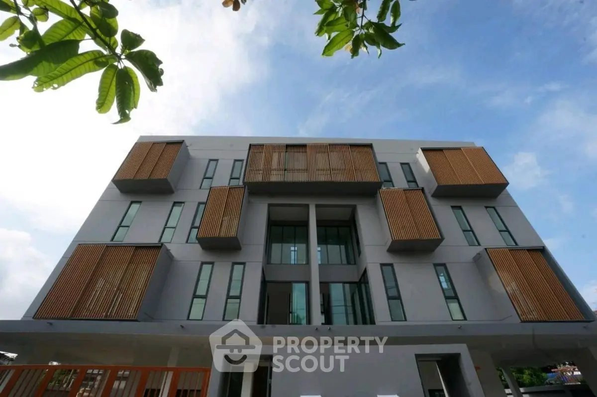 Modern architectural building with unique facade design and large windows, perfect for urban living.