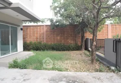 Spacious backyard with lush greenery and privacy fence in modern home