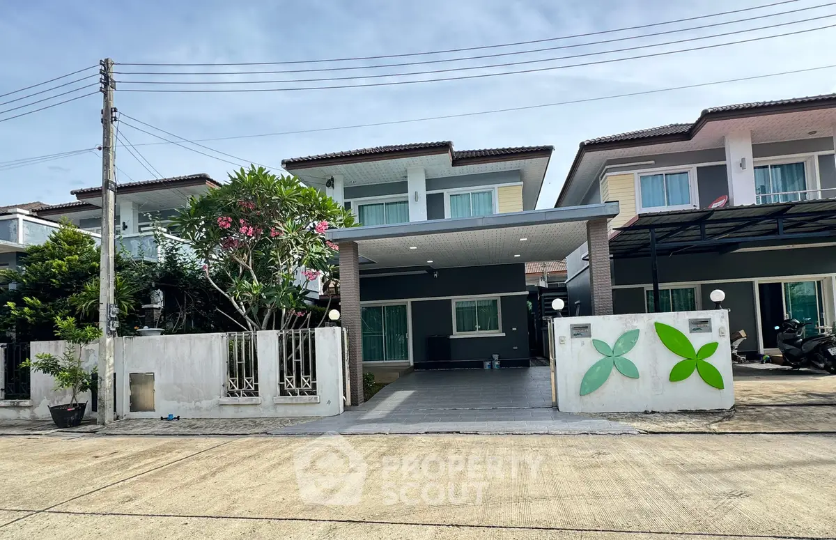 Modern two-story house with carport and landscaped front yard in a suburban neighborhood.