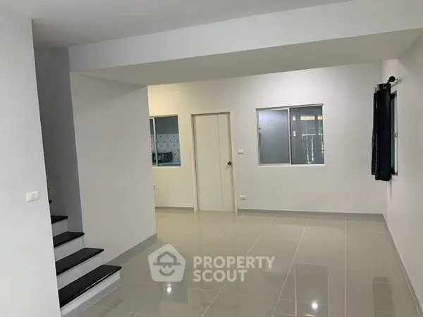 Spacious modern interior with sleek tiled flooring and neutral walls, perfect for customization.