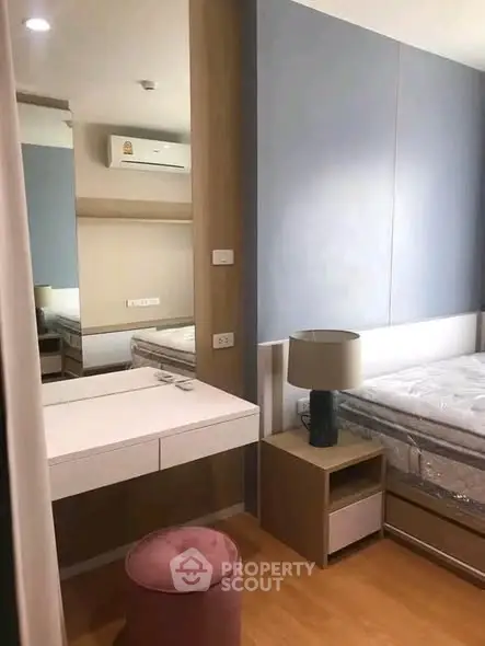 Modern bedroom with stylish furniture and soft lighting, featuring a cozy bed and elegant vanity area.