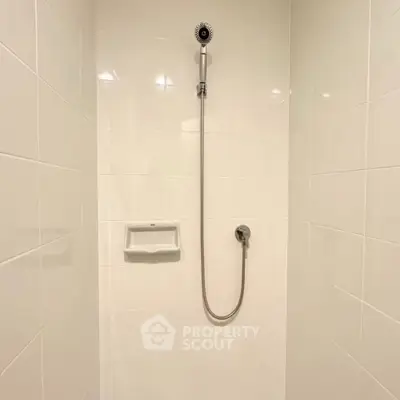 Modern minimalist shower with sleek white tiles and chrome fixtures