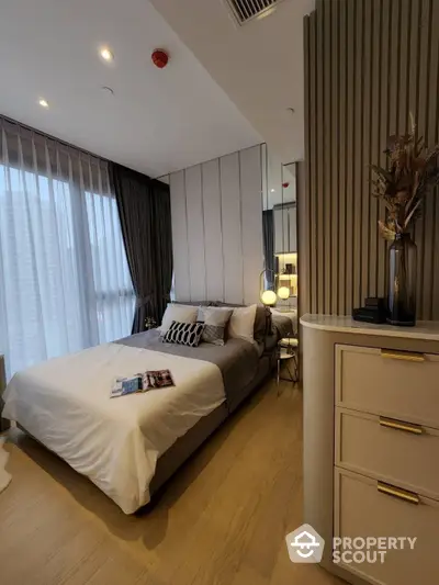 Elegant bedroom with a large comfortable bed, stylish decor, and ample natural light filtering through sheer curtains, perfect for relaxation and tranquility.