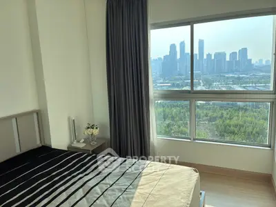 Modern bedroom with stunning city view and large window, featuring stylish decor and natural light.