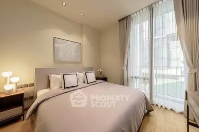 Luxurious bedroom with elegant decor and large window offering natural light