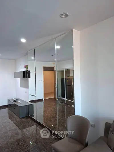 Modern living room with sleek mirrored wall and elegant marble flooring