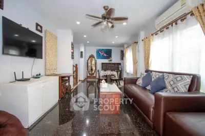 Spacious living room with modern decor, leather sofa, and large windows for natural light.
