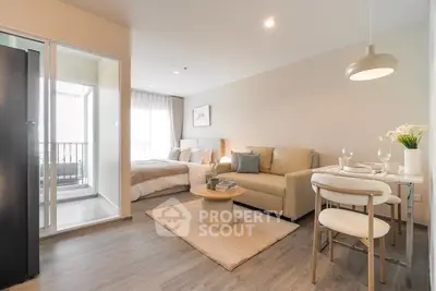 Modern open-plan living room with cozy seating and dining area, leading to a bright balcony.