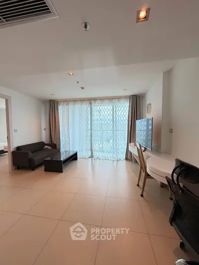 Spacious modern living room with large windows and stylish furniture in a high-rise apartment.