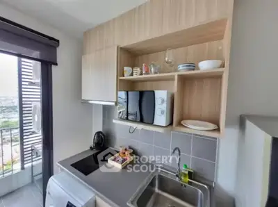 Modern kitchen with sleek cabinetry, built-in microwave, and scenic balcony view.