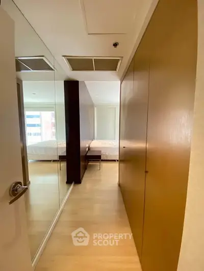 Spacious bedroom with mirrored closet doors and wooden flooring