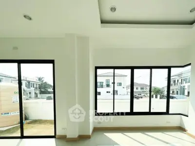 Bright modern living room with large windows offering a view of a suburban neighborhood.