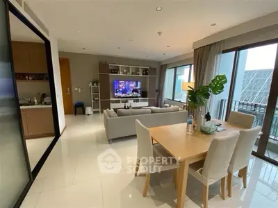 Modern living room with open layout, stylish furniture, and large windows offering natural light.