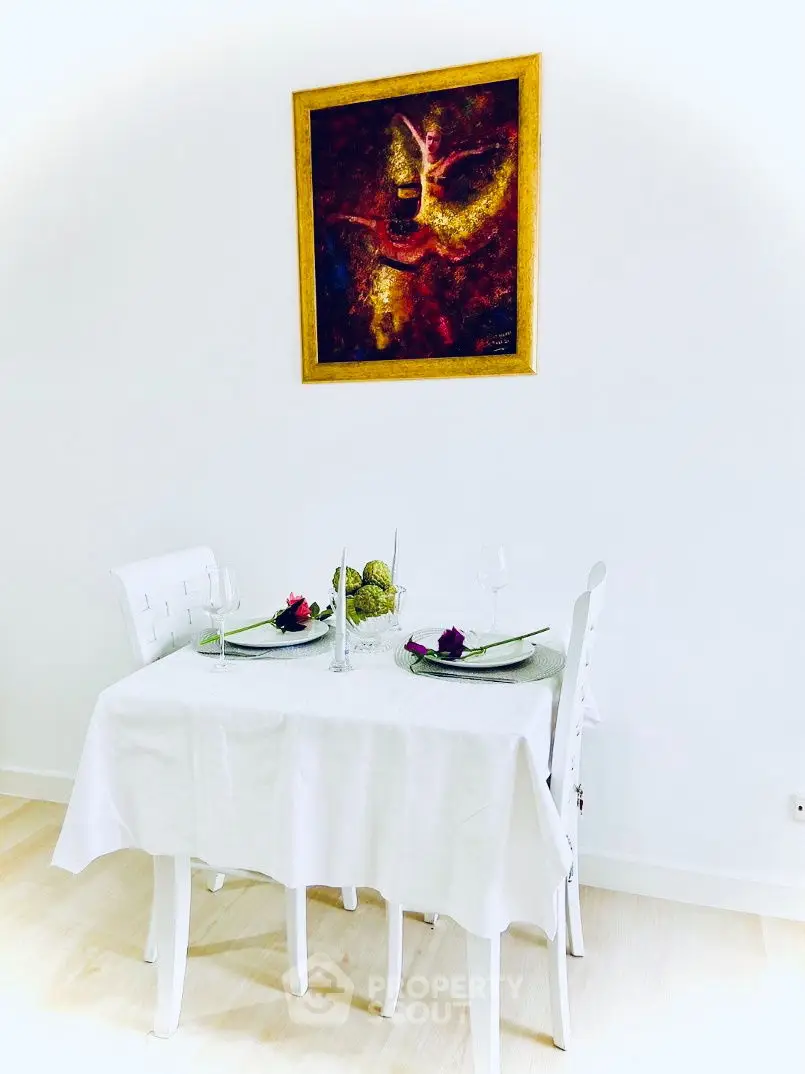 Elegant dining area with modern art and white decor