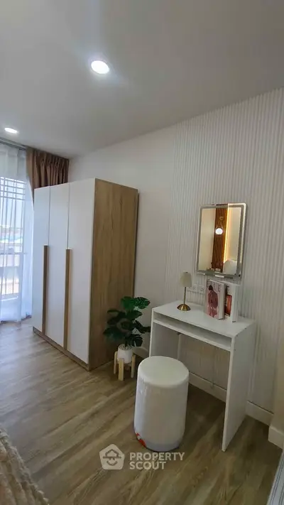 Stylish bedroom with modern wardrobe and vanity, featuring elegant decor and natural light.