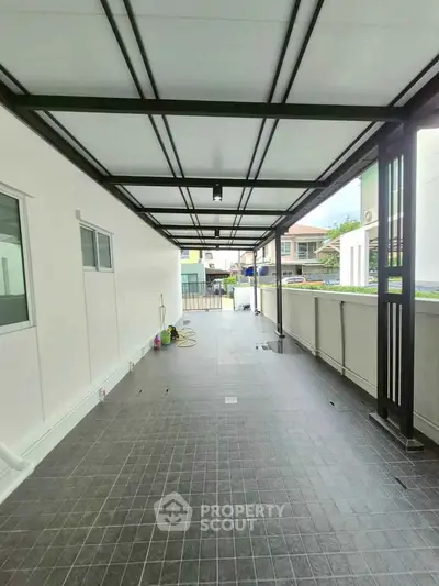Spacious covered outdoor area with tiled flooring and modern design, perfect for versatile use.