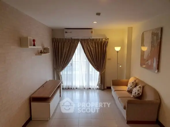 Cozy living room with natural light, elegant curtains, and comfortable seating in a modern apartment.
