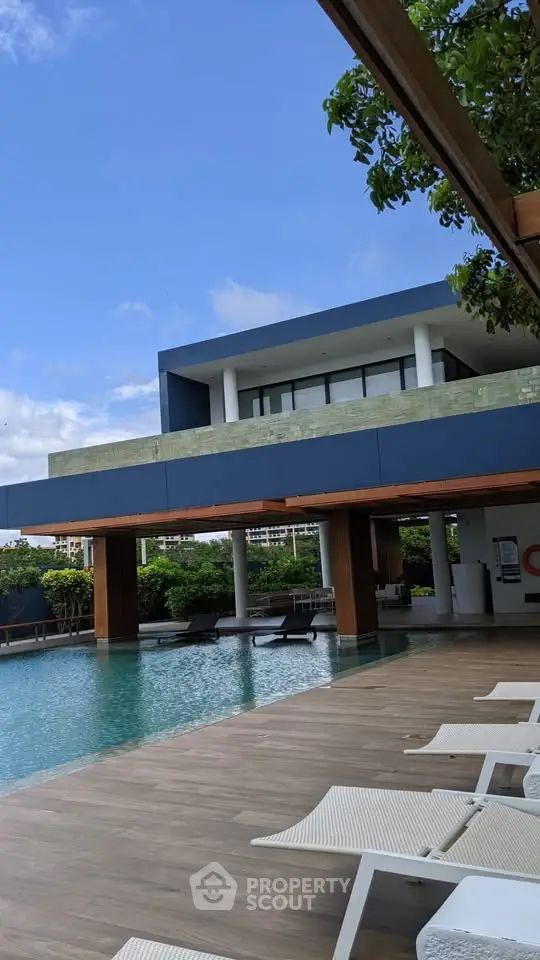Luxurious modern building with stunning poolside view and elegant architecture.