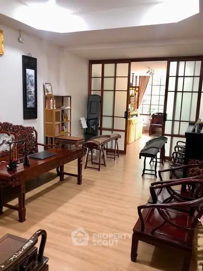 Elegant living room with traditional wooden furniture and sliding doors, perfect for a cozy and stylish home.