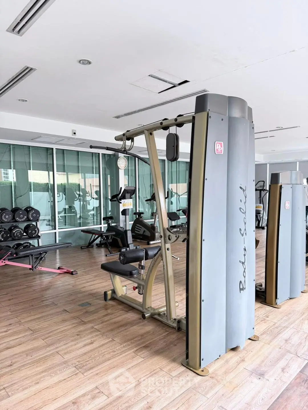 Spacious modern gym with state-of-the-art fitness equipment and wooden flooring.