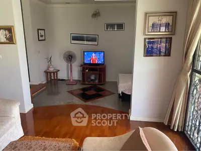 Cozy living room with wooden flooring, TV, and elegant decor