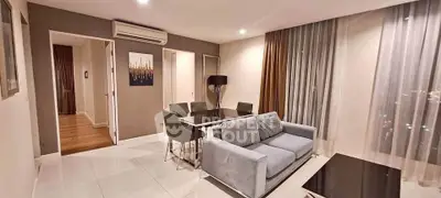 Modern living room with sleek furniture and large windows offering city views.